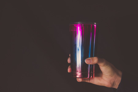 Photograph of a metallic colorful glass and human handの写真素材