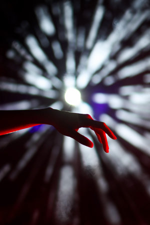 Hand of a girl dancing in the night club on a dark background