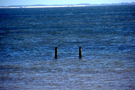 Two groynes stick out of the water at high tideの写真素材