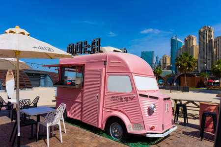 Dubai,UAE 10.31.2018 : Pink retro Note food caffee truck bus with skyscrapers in the backgroundのeditorial素材