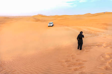 Desert landscape in Dubai with a woman and a desert safari carの写真素材