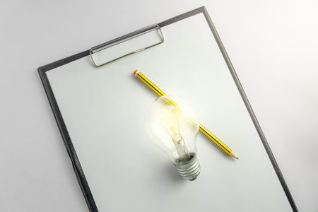 Blank paper with an light bulb and pencil waiting for idea concept with light