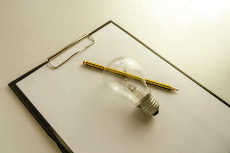 Blank paper with an light bulb and pencil waiting for idea concept minimalistの写真素材