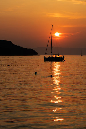 sunset on the sea with sailboats and islad silhouette ,の写真素材