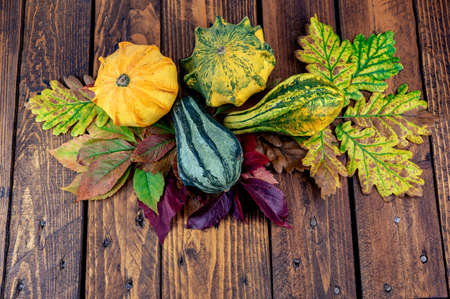 decoration pumpkins on wooden background with autumn leaves .の写真素材