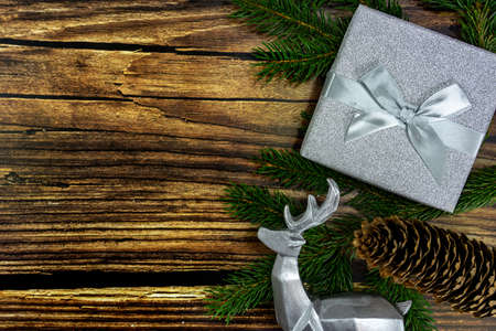 wooden brown background with silver gift box and deer decoration .の写真素材
