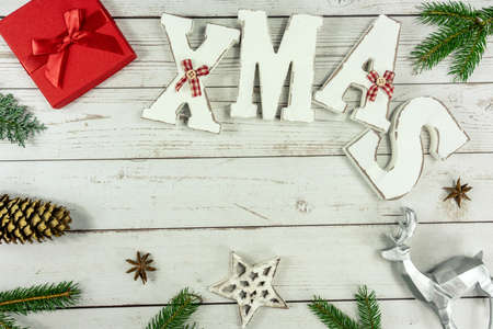 Christmas frame background flat lay on white wood with red gift box xmas text and other natural decorationの写真素材