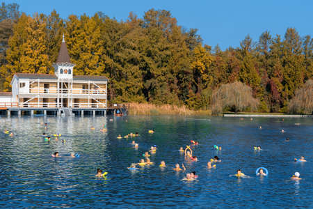 Heviz, Hungary 10.08.2019 : people swimming in famous Heviz balneal thermal bath pond in Hungary park autumn seasonのeditorial素材