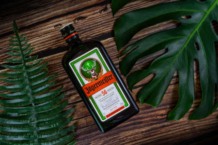 Tanakajd, Hungary - 112. 11. 2019 : Bottle of Jägermeister on weathered wooden background with leaves herbsのeditorial素材