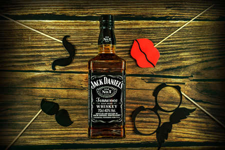 Tanakajd, Hungary - 112. 11. 2019 : Bottle of Jack Daniel's whiskey on weathered wooden background with playfu party photo accessoriesのeditorial素材