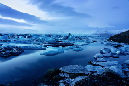 iceland glacier jokulsarlon in the evening icebergs floating on the cold peaceful water after sunset...