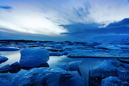 iceland glacier jokulsarlon in the evening icebergs floating on the cold peaceful water after sunset...