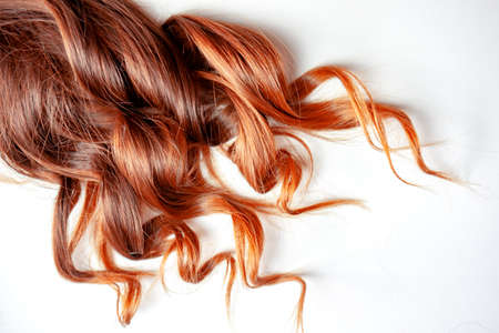 nice strawberry colored red curly hair on isolated white backgroundの写真素材