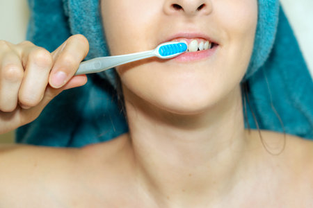woman washing her teeth after shower daily routine .