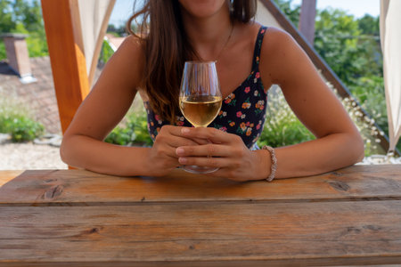 woman sitting nest to the table with a white wine glass .