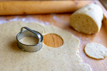 making traditional rustic linzer biscuit cookies vintage baking with a jar of jamの写真素材