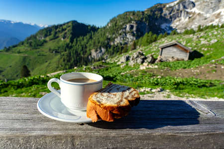 drinking a cup of caffee with breakfast over the mountains in tyrol on a hut terrasseの写真素材