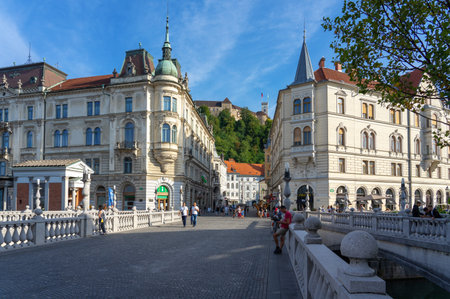 09.08.2021: Ljubljana, Slovenia: Preseren Square with Tromostovje bridge on Ljubljanica river and the Ljubljana castle Ljubljanski grad Laibacher Schloss downtown with peopleのeditorial素材