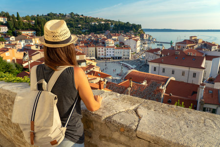 tourist woman with backpack watching Piran and the Tartini square