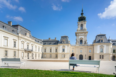 Beautiful baroque Festetics Castle building in Keszthely Hungary with a woman sitting on a benchの写真素材