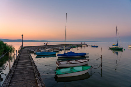 calm idyllic picture about boats next to the pier at sunset in Balatonlelle at Lake Balatonの写真素材