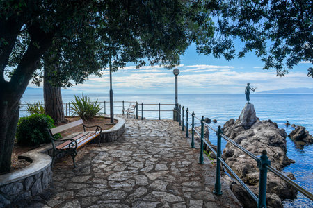 Opatija lungomare promenade with the Maiden with the Seagull statue and benchの写真素材
