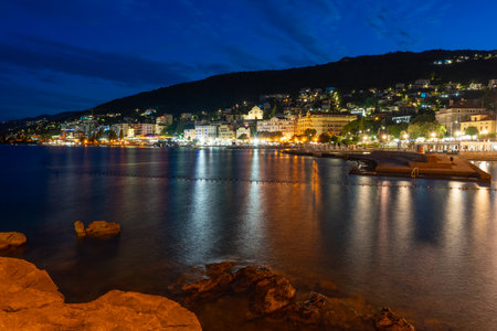 Night view of Opatija, Croatia with city lights reflecting on the Adriatic Seaの写真素材