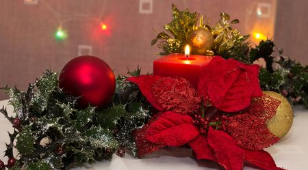 A red christmas candle amongst christmas decorationsの写真素材