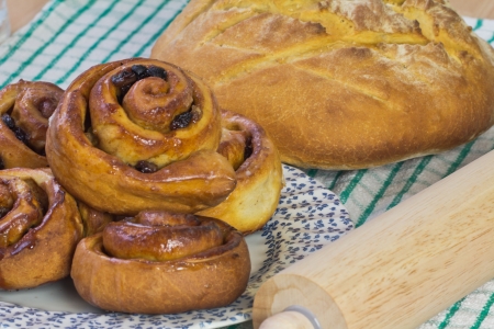 Fresh homebaked bread and buns with a rolling pinの写真素材