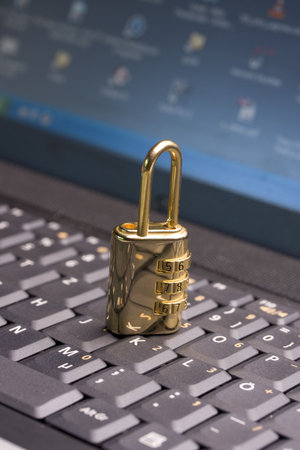 a golden padlock on a black notebook keyboard
