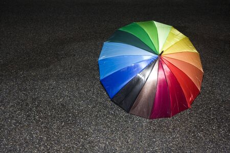 rainbow colored umbrella on tarmacの写真素材