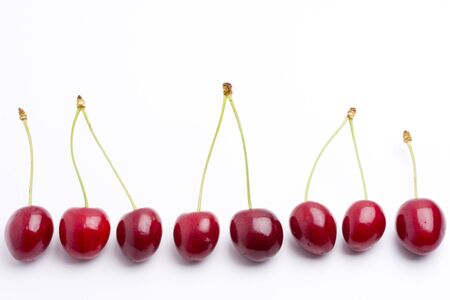 row of red cherries on white backgroundの写真素材