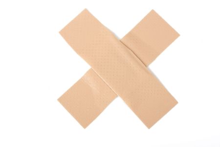 a cross of bandaids on white backgroundの写真素材