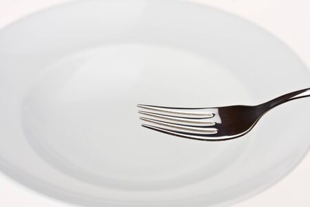 fork on a white plate isolatedの写真素材