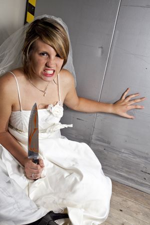 angry young bride with a bloody knife in an elevatorの写真素材