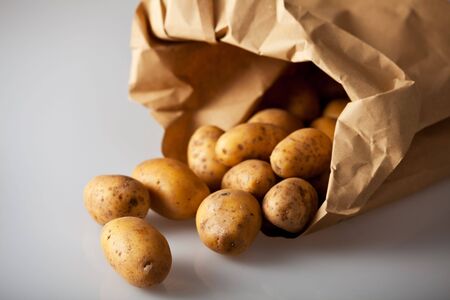 fresh potatoes in a brown paper bagの写真素材