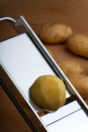 half a potato on a mandolin slicerの写真素材