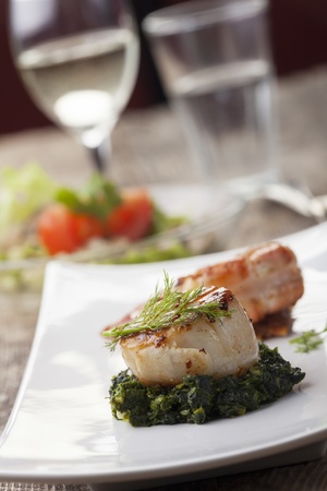 closeup of a grilled scallop on spinach の写真素材