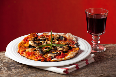 closeup of a champignon pizza on a wooden tableの写真素材
