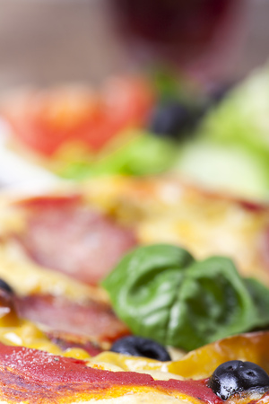 closeup of a pizza with a basil leaf の写真素材