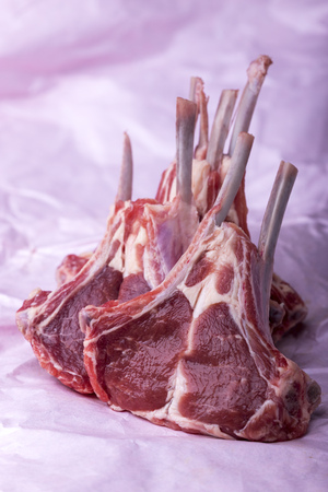 raw lamb chops on pink papaerの写真素材