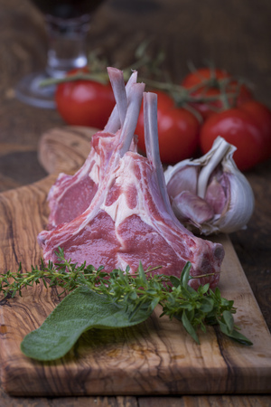 raw lamb chops with herbs on woodの写真素材
