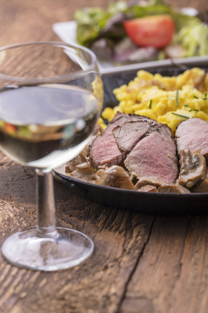 white wine and swabian pork filet with spaetzle on woodの写真素材
