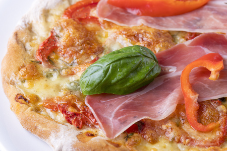 detail of a pizza with ham and basilの写真素材