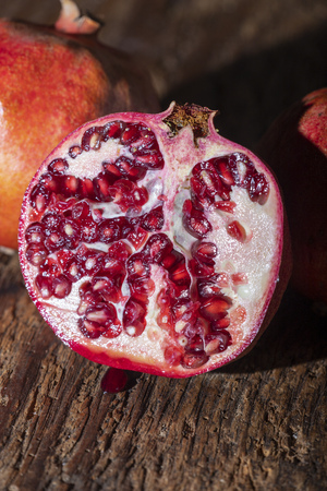 three pomegranades on dark woodの写真素材