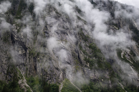 fog rising on a mountain in the alpsの写真素材