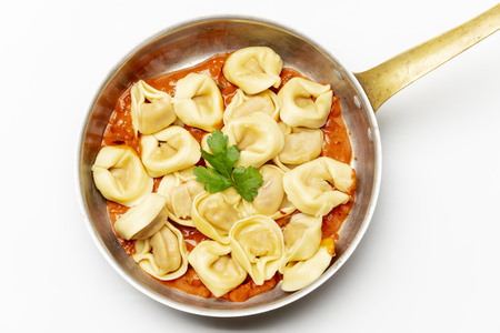 tortellini on white with tomato sauceの写真素材