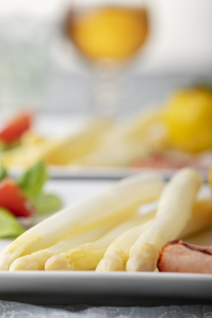cooked white asparagus with ham and potatoの写真素材