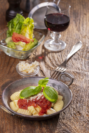 closeup of gnocchi with sauce on woodの写真素材