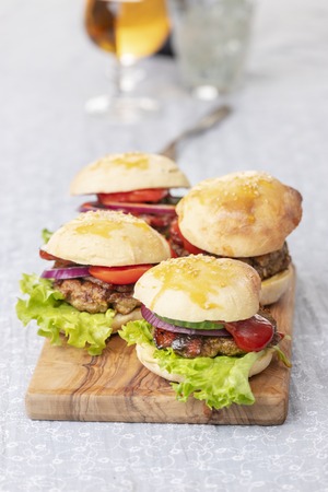 four hamburgers on dark woodenの写真素材